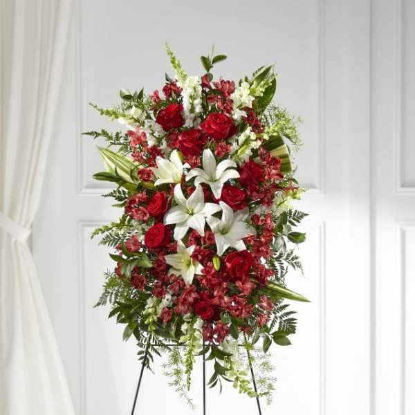 Standing floral spray with red roses, white lilies, and pink accents