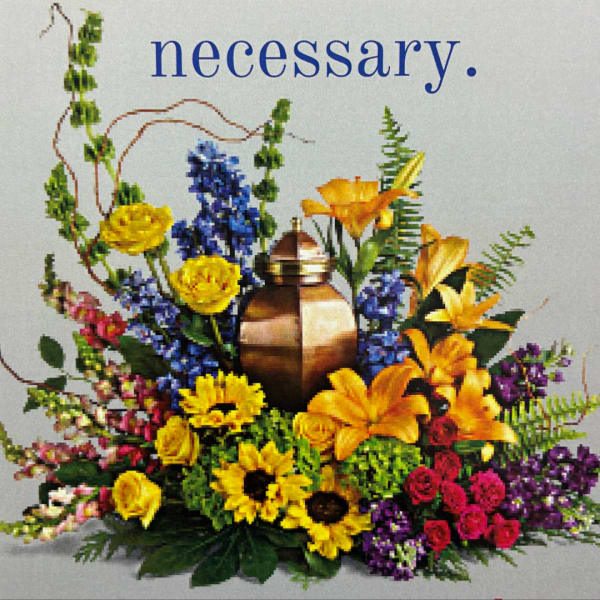 Colorful floral arrangement around a bronze urn with a blue word above it