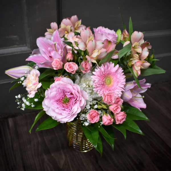 Pink mixed flower arrangement in a gold vase