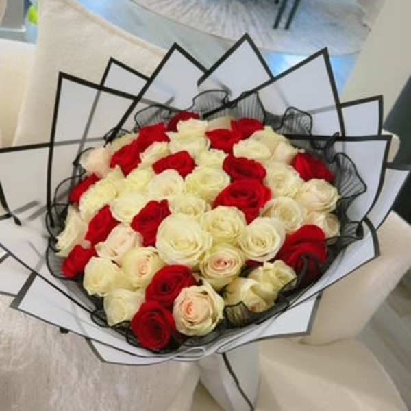 Bouquet of red and white roses wrapped in black and white paper