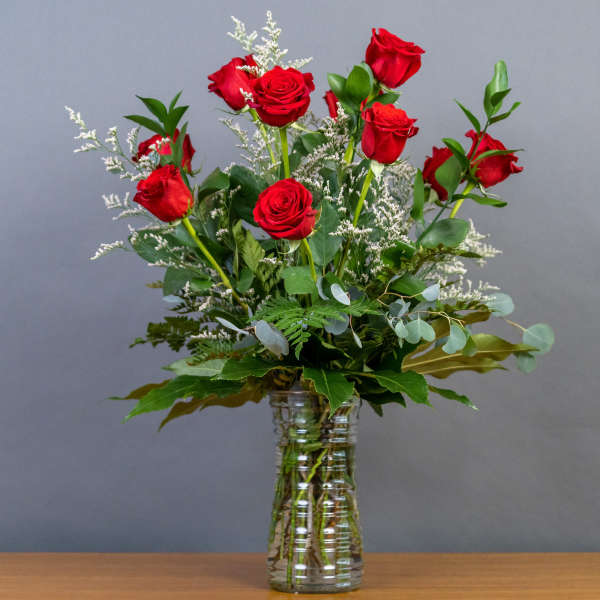 Red roses arranged in a clear glass vase