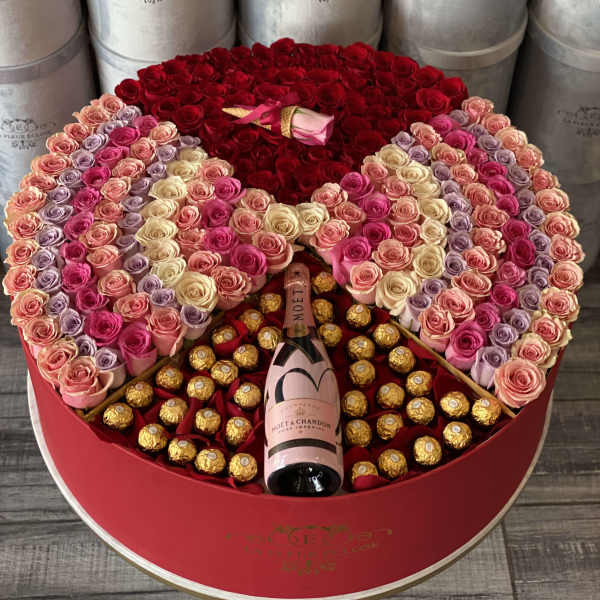 Heart-shaped box of roses with a champagne bottle and chocolates