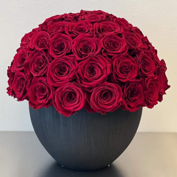 Round bouquet of red roses in a black vase