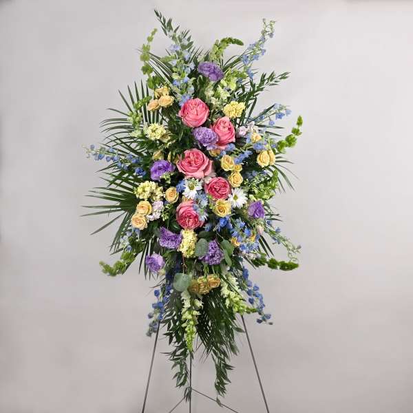 Tall standing floral spray with pink, purple, yellow, and blue flowers