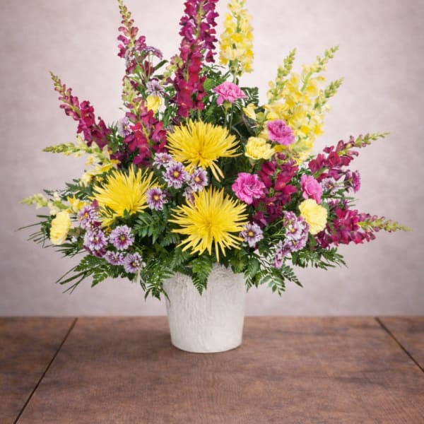 Colorful mixed flower arrangement in a white pot