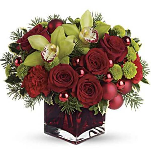 Red roses and green orchids in a square glass vase