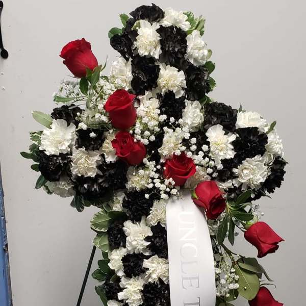 Standing floral cross with red roses and black-and-white carnations