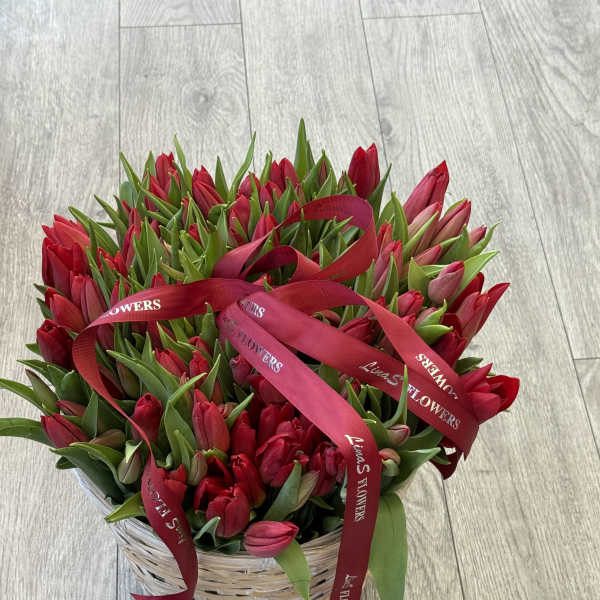 Basket of red tulips tied with red ribbons