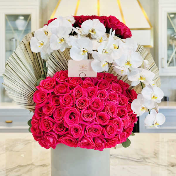 Hot pink roses with white orchids in a gray vase