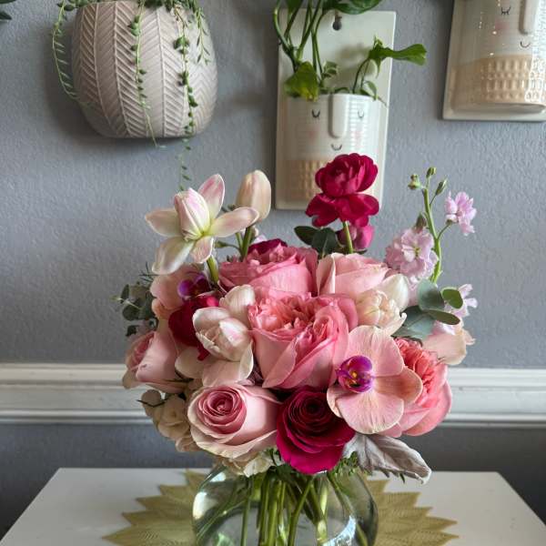 Pink and white rose bouquet in a clear glass vase
