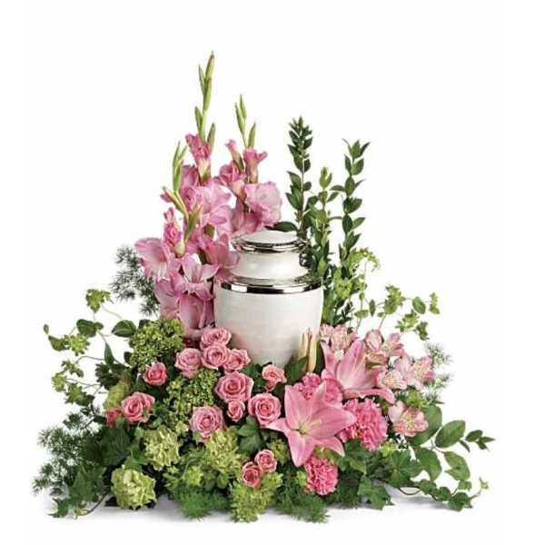 Pink floral arrangement around a silver urn