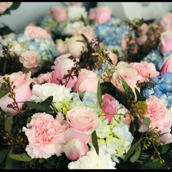 Pastel bouquets with pink roses, carnations, and blue hydrangeas