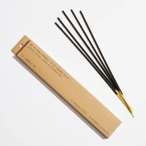 Box of incense sticks beside several loose incense sticks