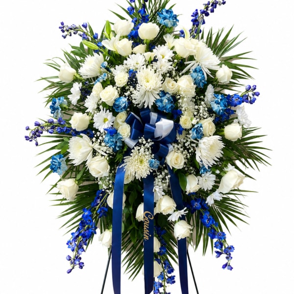 Large blue and white floral standing spray with ribbon on an easel