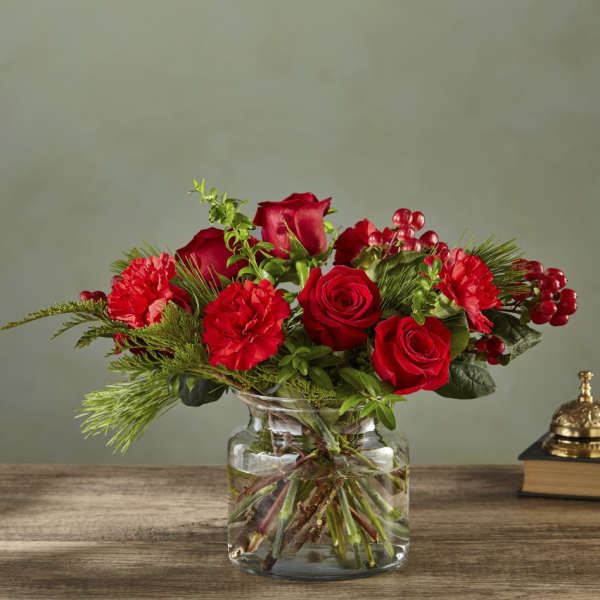 Red roses and carnations in a clear glass vase