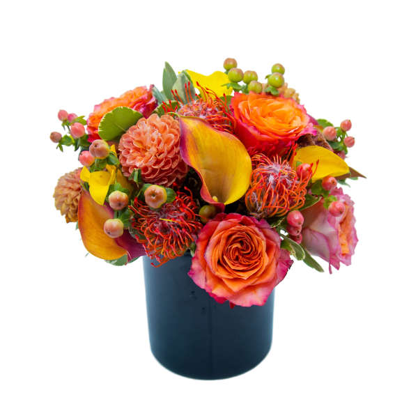 Bright mixed bouquet in a dark vase with orange and yellow blooms
