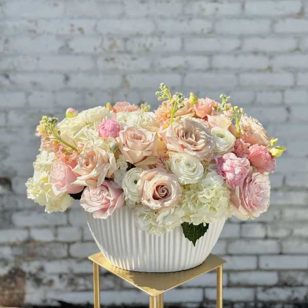 Pastel rose and hydrangea arrangement in a white ribbed bowl