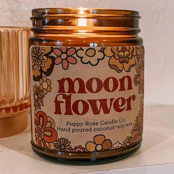Amber glass candle jar labeled "moon flower" with floral graphics