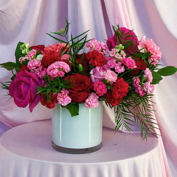 Pink and red flower arrangement in a white vase