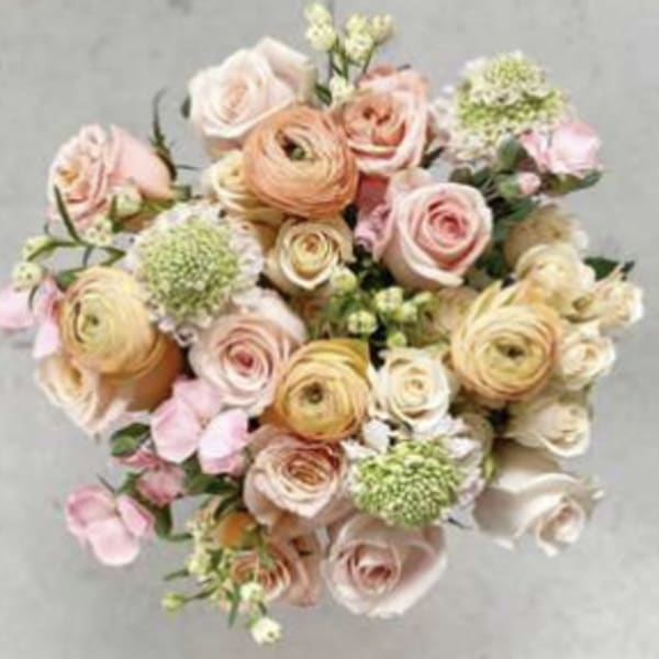 Bouquet of blush and peach roses with pale green blooms