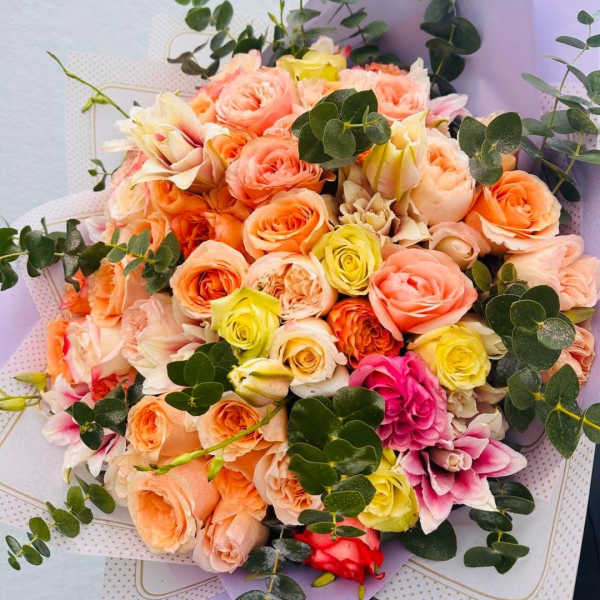 Bouquet of peach, pink, and yellow roses with eucalyptus