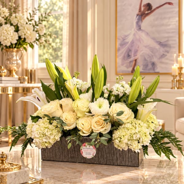 Cream roses and lilies arranged in a rectangular wooden box