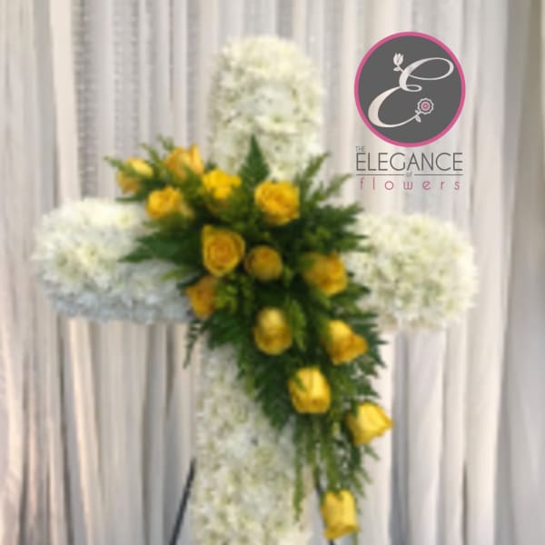 Yellow roses on a white floral cross stand arrangement