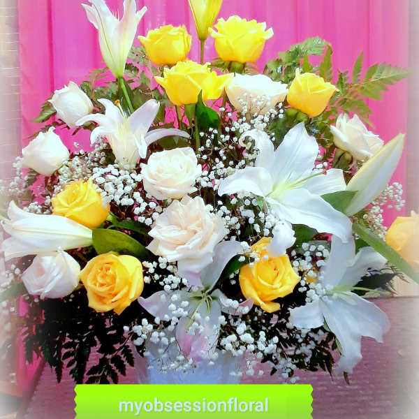 Bouquet of yellow and white roses with white lilies in a vase