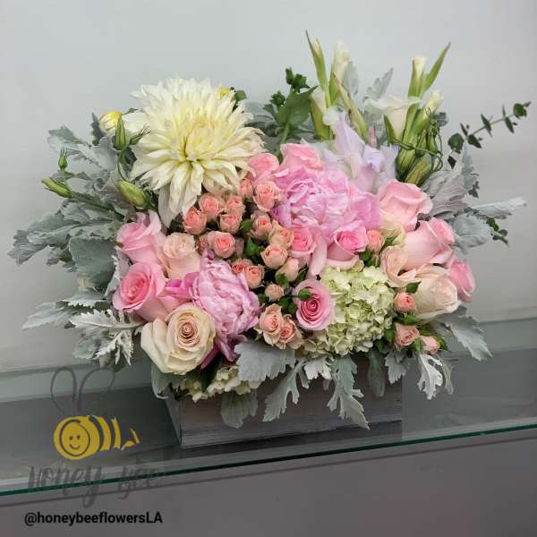 Pink and white floral arrangement in a wooden box