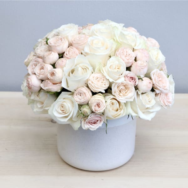 Blush and white rose bouquet in a white vase