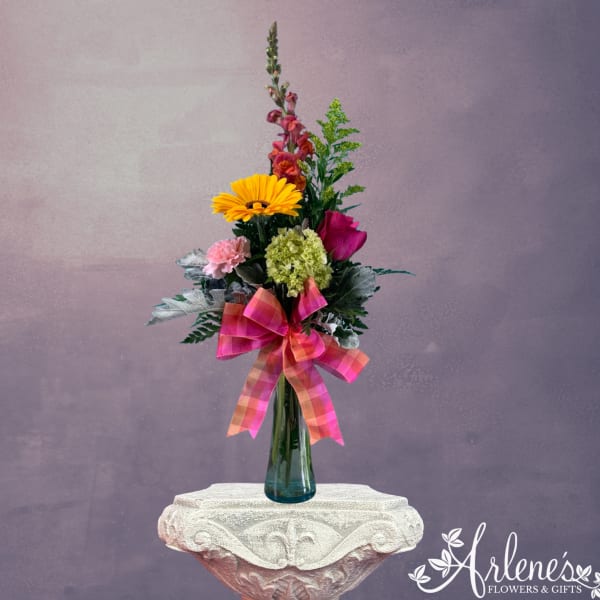 Tall mixed bouquet in a blue glass vase with a pink plaid ribbon