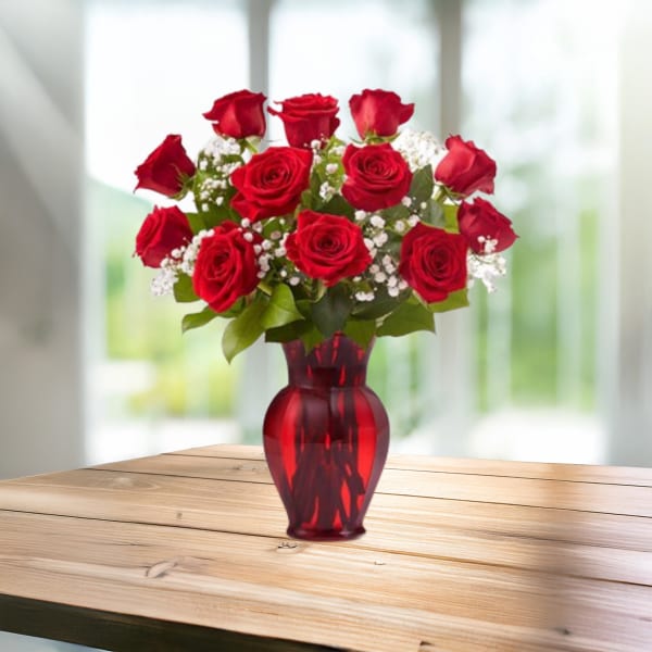 Red roses arranged in a red glass vase