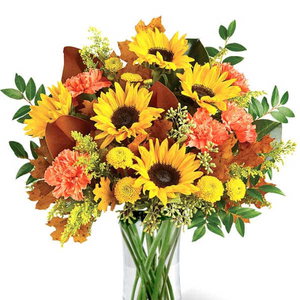 Sunflower and orange carnation bouquet in a clear glass vase