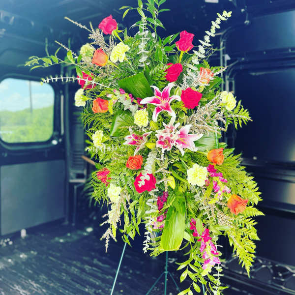 Tall floral spray with pink, orange, and white blooms on a stand