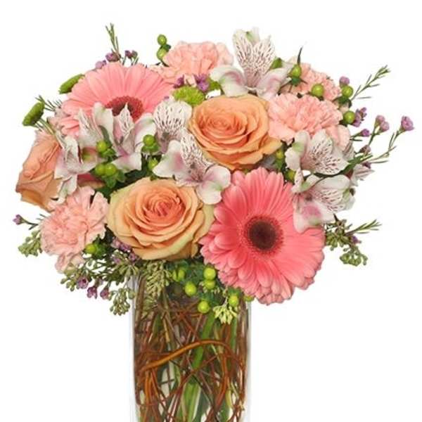 Pink and peach mixed bouquet in a clear rectangular vase