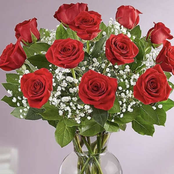 Bouquet of red roses with baby's breath in a clear glass vase
