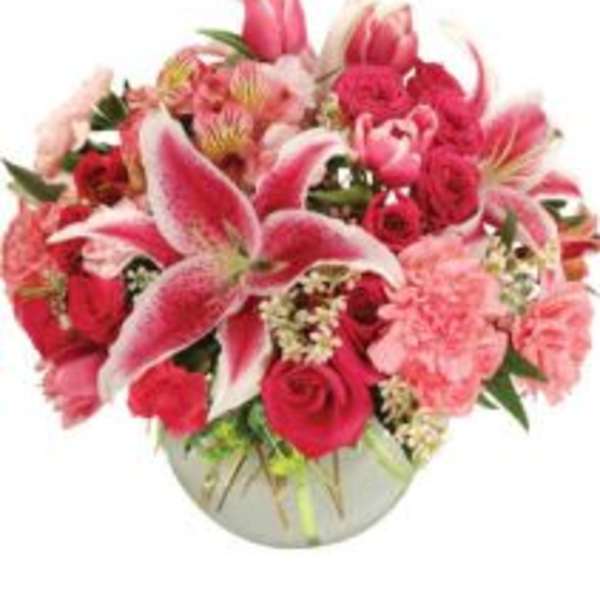 Pink lilies and roses arranged in a round vase