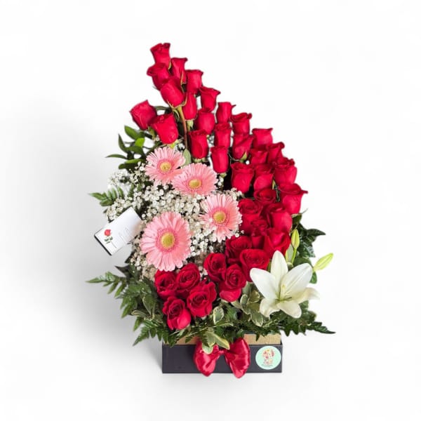 Red roses with pink gerberas and a white lily in a gift box