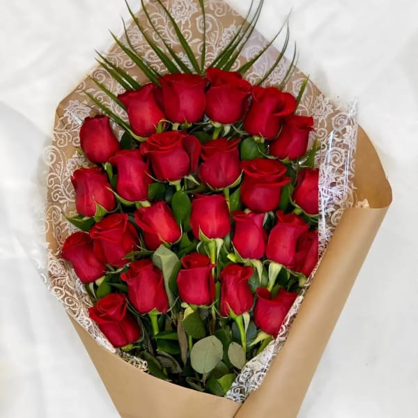 Bouquet of red roses wrapped in brown paper with lace trim