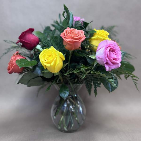 Bouquet of multicolored roses in a clear glass vase