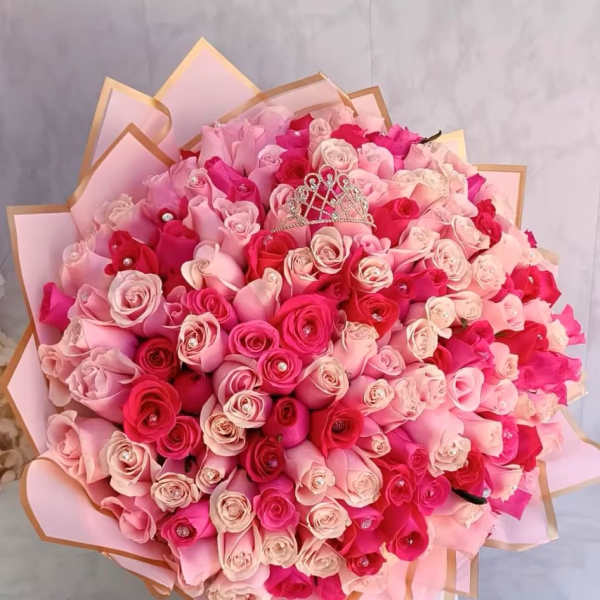 Large bouquet of pink and red roses with a small tiara topper