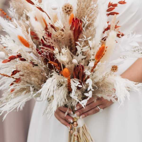 Bride holding a dried bouquet with white and rust accents
