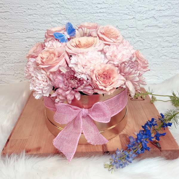 Pink rose and chrysanthemum arrangement in a round box with a pink bow