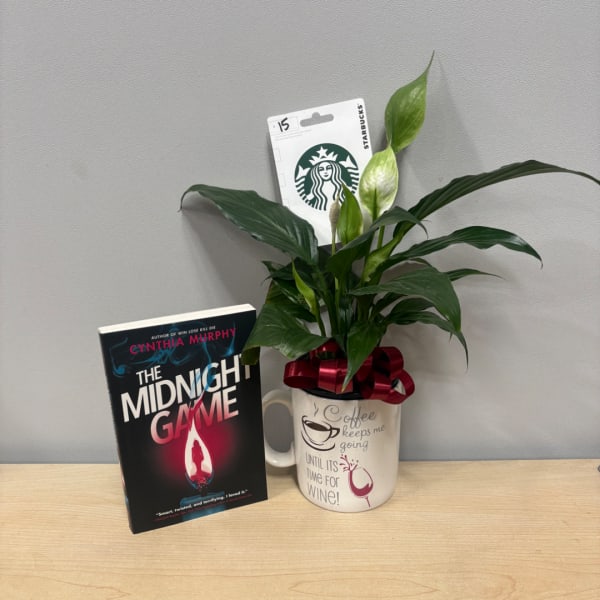 Potted peace lily in a mug with a ribbon, beside a book and Starbucks card