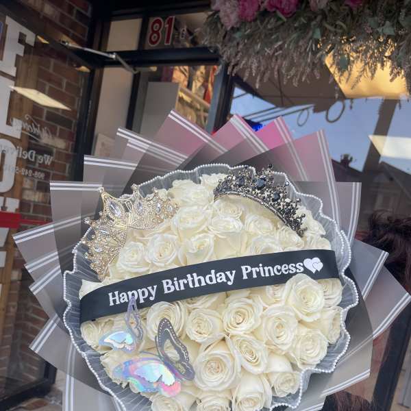 Bouquet of white roses with crowns and a birthday ribbon