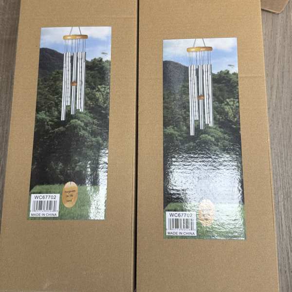 Two cardboard boxes with pictures of silver wind chimes on the front.