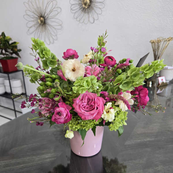 Pink and white floral arrangement in a pink vase