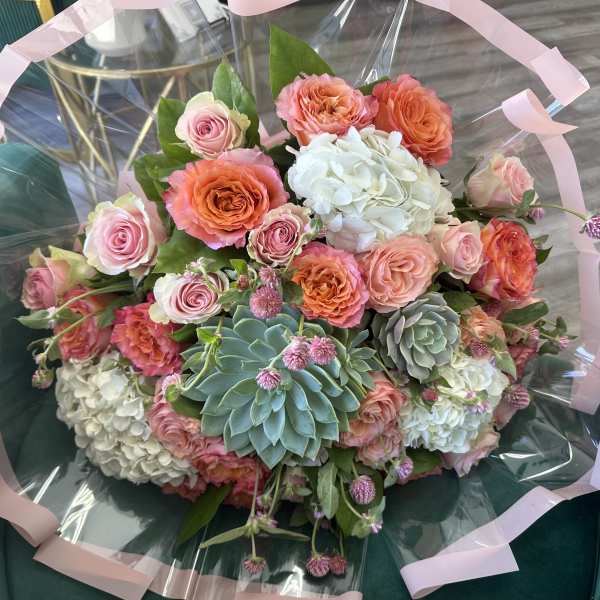 Bouquet of pink and orange roses with white hydrangeas and succulents