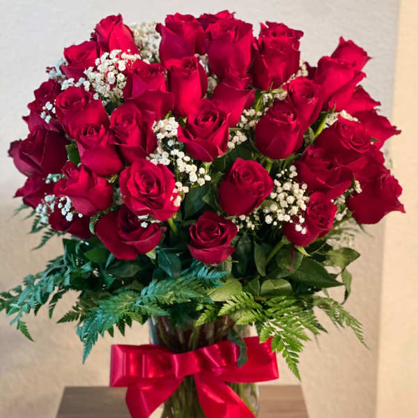 Bouquet of red roses in a glass vase with a red ribbon