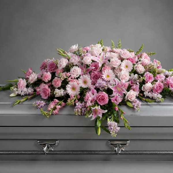 Pink floral spray arranged on a silver casket